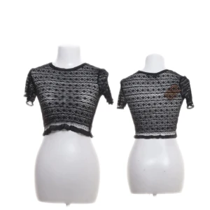 Svart spetsig croppad topp från Zara - Svart croppad topp från Zara i spets med korta ärmar och volangkant nertill. Toppens spetsmönster ger en cool och trendig vibe, perfekt att styla med höga jeans eller kjol. Rund halsringning och transparent material för en edgy look.