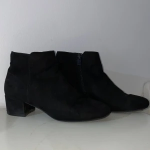 Svarta mocka boots från XIT - Snygga svarta boots från XIT i mjuk mocka med låg klack och rund tå. Skorna har dragkedja på sidan för enkel på- och avtagning. Perfekta för dig som vill ha en stilren och klassisk look till höst och vinter. Svart skor som passar bra nu för hösten. Allt är som i bilden, meddela mig gärna för mer info! 💕