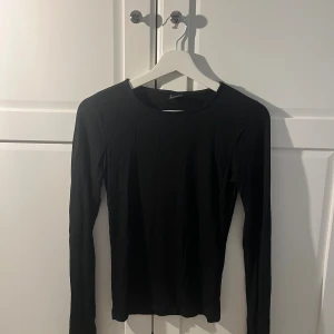 Svart långärmad topp från Gina Tricot - En svart långärmad topp från gina tricot i storlek S. Modellen är figurnära med rund halsringning och tillverkad i mjukt bomullsmaterial. Använd endast fåtal gånger