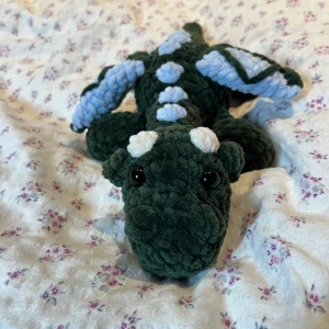 Virkad mörkgrön och blå drake  - När man är klar med tenta så får man fira lite!🩷🎉🎊Så kommer två nya drakar, denna i mörkgrön och ljusblå🥹💚💙 !Dessa innehåller säkerhetsögon som inte rekommenderas för barn under 3 år!