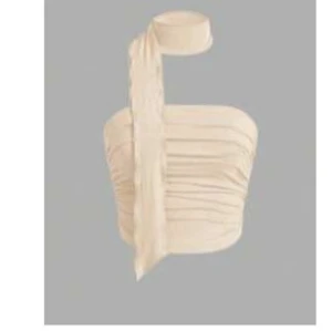 Beige omlott tubtopp med scarfdetalj - Trendig beige tubtopp med omlottkänsla och snygg scarfdetalj som knyts runt halsen. Toppen har en lätt rynkad struktur och är perfekt för dig som vill sticka ut med en unik och stilren look.