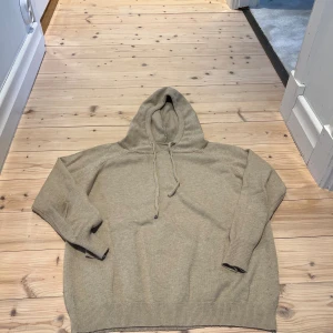Kashmir hoodie  - Säljer en beige stickad hoodie med huva och snörning. Tröjan har ribbade muddar vid ärmslut och nederkant, samt en relaxed passform. Perfekt för dig som gillar en enkel och stilren look. Det är storlek S vilket passar runt 170! Priset går att diskutera!💸MVH //Alve