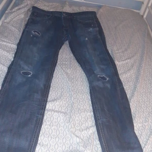 Förlåt för kvaliten på luren  - Säljer ett par blå jeans från Jack & Jones med slitningar och hål på knäna. Jeansen har klassisk femficksdesign, tydliga kontrastsömmar och en något tvättad look. Perfekta för dig som gillar en avslappnad och trendig stil.