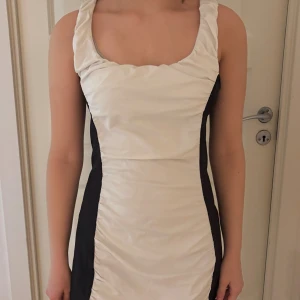 Vit och svart kort klänning Gina Tricot - Supersnygg kort klänning från Gina Tricot i vit och svart. Klänningen har breda axelband. Storlek L 