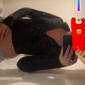 Svart croppad långärmad topp - Snygg svart croppad topp med lång ärm och djup v-ringning. Perfekt att styla med jeans eller kjol för en trendig look. Toppens material är stretchigt och sitter tight mot kroppen för en modern siluett.