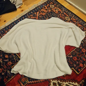 Vit ribbad topp från Kappahl - Säljer en vit ribbad topp från Kappahl i storlek M. Toppen har en lös passform med breda, korta ärmar och rund halsringning. Materialet är mjukt och lätt, perfekt för en chill och stilren look.