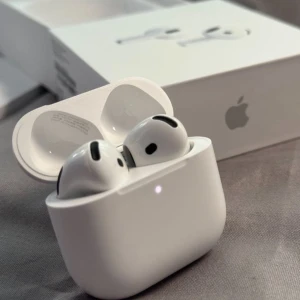 AirPods 4 - Apple AirPods 4 i mycket fint skick, komplett med originalförpackning och laddningsetui. Trådlösa hörlurar med utmärkt ljud, lång batteritid och smidig anslutning till Apple-enheter. Inga synliga repor eller skador, ser nästan nya ut.