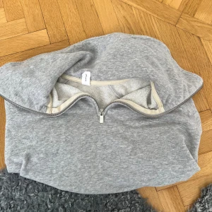 Grå tröja med dragkedja från C.W. - Säljer en grå hoodie från C.W. i storlek M. Tröjan har en halv dragkedja framtill, perfekt för lager-på-lager. Tillverkad i mjuk bomullsblandning som känns skön mot huden. Enkel och stilren design som funkar till det mesta.