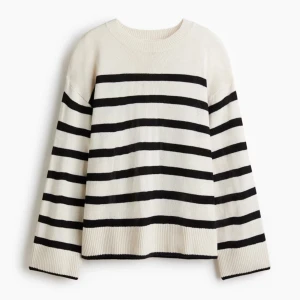 Randig stickad tröja från Divided - Snygg stickad tröja från Divided i vitt/kräm med svarta horisontella ränder. Tröjan har rund halsringning, långa ärmar och ribbade muddar vid ärmslut och nederkant. Perfekt för dig som gillar klassisk och avslappnad stil.