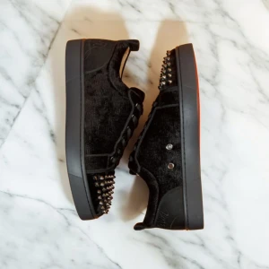 Christian Louboutin svarta sneakers med nitar - Svarta sneakers från Christian Louboutin i mocka med klassiska röda sulor och svarta nitar på tån. Skorna låter dig se ut som grischinator. Kontakta mig om ni vill diskutera pris.