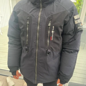 Svart Sail Racing vinterjacka herr - Säljer min Sail Racing jacka i toppskick. Jackan är knappt använd och ser nästan ny ut – inga skador, fläckar eller slitage. Modellen finns inte längre att köpa i butik, vilket gör den extra unik och eftertraktad för den som gillar Sail Racing.   Nypris: ca 7000 kr  Mycket bra skick  Svår att få tag på idag  Perfekt för dig som vill ha en stilren och funktionell jacka med Sail Racings välkända kvalitet.