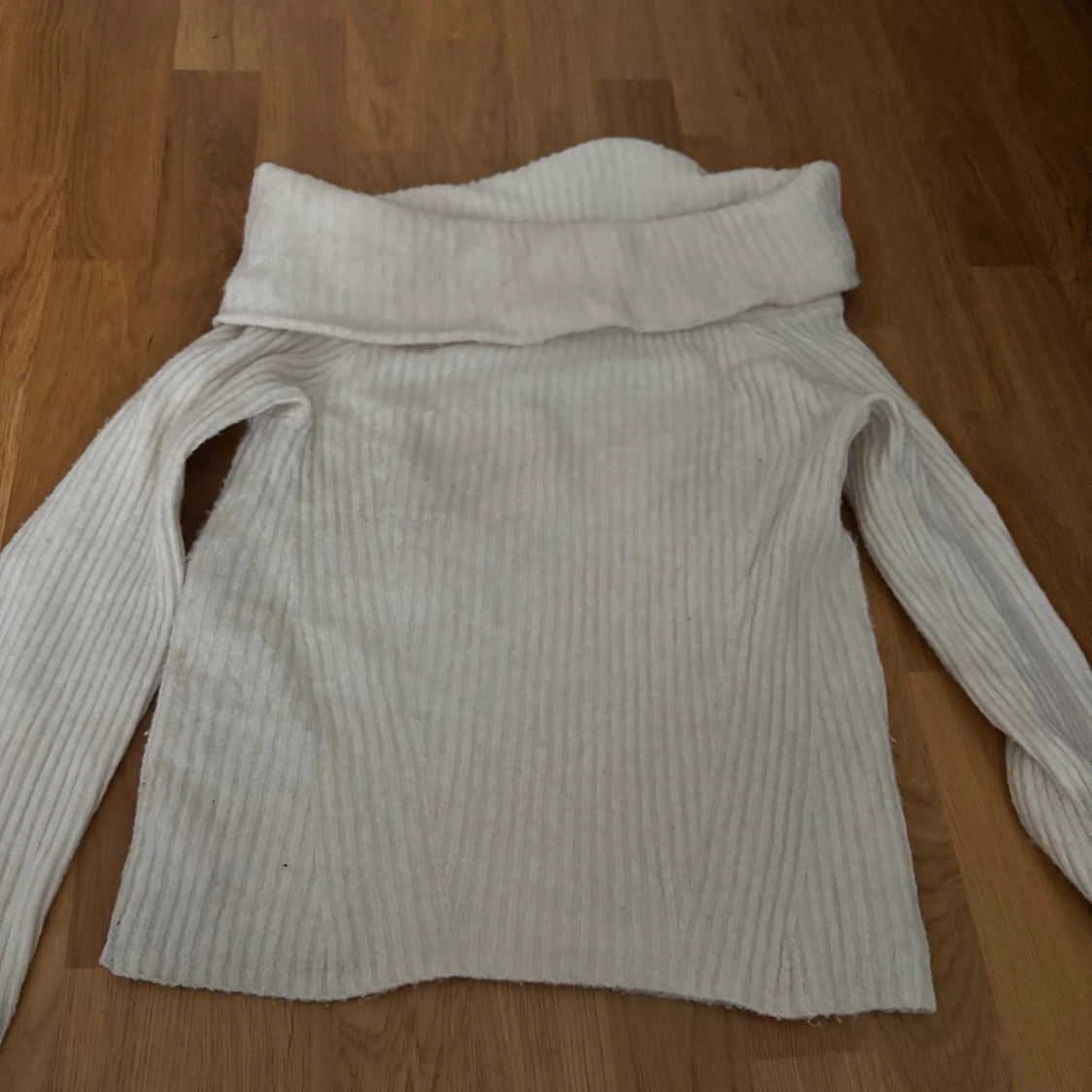 Vit ribbad polotröja i stickat material