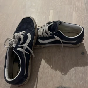Mörkblå Vans Old Skool sneakers - Säljer ett par klassiska Vans Old Skool sneakers i mörkblå mocka med vita detaljer och snörning. Priser kan diskuteras och dem är i väldigt bra skick.