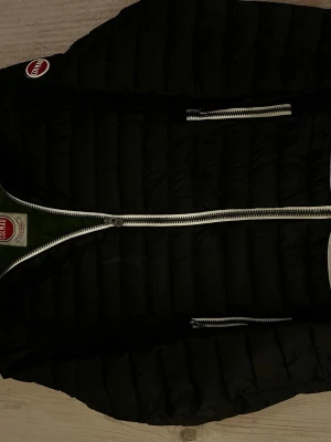 Svart Colmar jacka med dragkedja - Svart jacka från Colmar med vit dragkedja och grönt material inuti.  Långärmad och med normal passform, perfekt för kyliga dagar. Jackan är använd men har inte några hål eller defekter. Passar bäst för personer i storlek S men funkar även för M. Fraktar på 1-2 dagar!