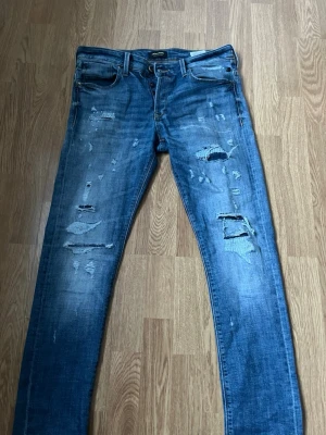 Blå slitna jeans från Jack & Jones - Säljer ett par blå jeans från Jack & jones. Kom med frågor fraktar snabbt