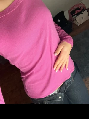 Rosa långärmad topp i bomull - Säljer en enkel och snygg rosa långärmad topp med rund hals. Toppen är i mjukt bomullsmaterial och har en normal passform som sitter skönt mot kroppen. Perfekt att matcha med jeans eller kjol för en chill look.