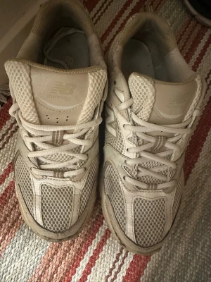 Beige New Balance 530 sneakers 40.5 - Säljer ett par beige New Balance 530 sneakers i storlek 40.5. Skorna har meshpaneler och detaljer i syntet, med snörning och rund tå. Perfekta för dig som gillar retrostil och sportig vibe. Klassisk New Balance-logga på sidan och plös.                               Slitna i tyget inuti och har ett litet hål på vänster sko. Inköpta i år :)