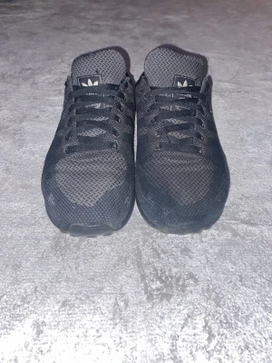 Svarta Adidas LA Trainer sneakers - Säljer ett par svarta Adidas LA Trainer sneakers med mesh-ovandel och klassiska skor på fotbollsplanen Perfekt för dig som gillar sportig stil. Dom har använts i ett år, funkar bra, bra skick. Priset är inte hugget i sten, DM för mer info.