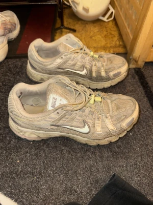 Beige Nike sneakers med mesh och snörning - Nike sneakers i beige med meshpaneler och syntetiska detaljer