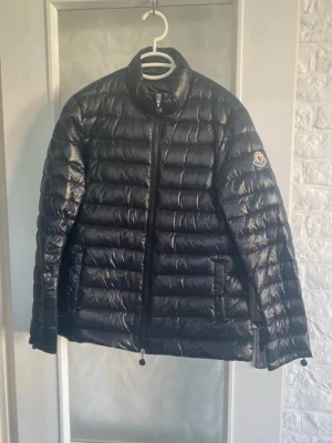 Svart pufferjacka - Svart pufferjacka som är köpt på Plick och fick ej med kvitto som lovat därav pris. Jackan har ståkrage, dragkedja framtill och dragkedjor vid ärmsluten. Quiltad design och två fickor med dragkedja. Perfekt för kalla dagar och riktigt snygg till streetwear. Liten i strl skulle säga s/m men står xl i jackan 