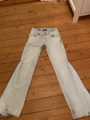 Ljusblå lågmidjade jeans - Säljer dessa ljusblå jeans som är omsydda till bootcut. Midjemått 36 cm och innerbenslängd 76 cm. De är i bra skick förutom att de har några fläckar längst ner vid benen. Kolla gärna min profil där jag säljer fler liknande jeans💗💗