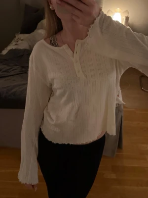 Vit långärmad sovtröja - Säljer en vit långärmad pyjamastopp från Lager157. Den är i storlek S och i mycket bra skick. Toppen har rund halsringning, fyra knappar framtill och vågiga kanter vid ärmslut och nederkant. Väldigt skön men jag hade önskat en storlek större så därför säljer jag den. Hör gärna av dig vid frågor🤍