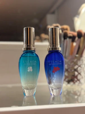 Escada Chiffon Sorbet & Santorini Sunrise - Escada Chiffon Sorbet EDT 30 ml Fräsch och somrig doft med fruktiga och blommiga toner. Luktar jättegott men är tyvärr inte riktigt min stil. Endast testad några få gånger, i princip som ny. Ingen originalförpackning.  Escada Santorini Sunrise EDT 30 ml Lätt, solig och fräsch doft med citrus och blommor. Väldigt fin sommardoft men inte helt jag. Använd väldigt sparsamt, nästan som ny. Ingen originalförpackning. Fått båda av min farmor,  men de kommer tyvärr inte till användning. Paketpris 250kr😇