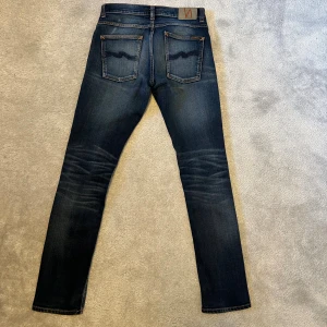 Mörkblå jeans från Nudie Jeans - Säljer ett par mörkblå jeans från Nudie Jeans i storlek 31/32. Jeansen har en riktigt najs färg och är i toppskick! Hör av er vid funderingar:) Säljer byxorna  eftersom de var för små.