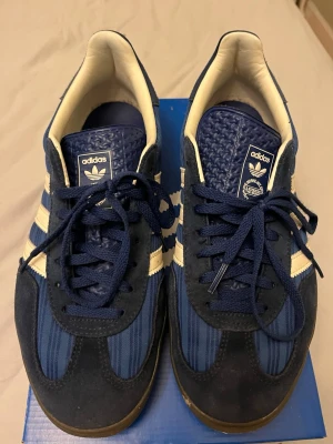 Adidas Gazelle Indoor blå sneakers - Säljer ett par Adidas Gazelle Indoor sneakers i marinblått. Materialet är bland annat mocka. Köpta på unisport i höstas för ca 1400. Storlek 42 2/3