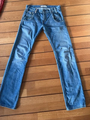 Levi's 504 blå jeans straight fit - Säljer ett par klassiska Levi's 504 jeans  i ljusblå tvätt med raka ben och fem fickor. Bästa passformen av alla Levis modeller enligt mig. Jeansen har normal passform och är tillverkade i slitstarkt bomullsmaterial. Snygga detaljer med Levi's patch och röd etikett på bakfickan.