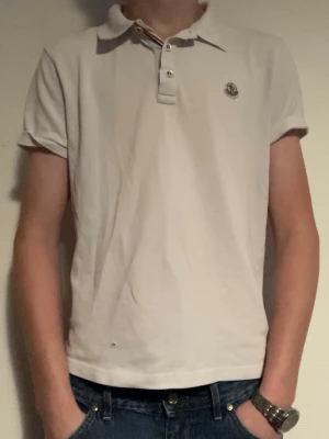 Vit Moncler piké med kort ärm - Tja, säljer min feta Moncler piké, piken har tyvärr ett litet hål vid nedre delen av tröjan(finns bild på bild 5). Ställ gärna frågor om ni eventuellt är intresserade 
