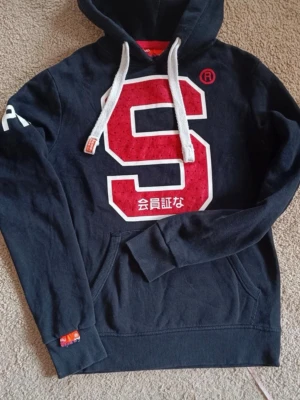 Superdry hoodie st xs/s (sällsynt) - Säljer denna stilrena superdry hoodie för endast 299kr. Hoodien är stor i storlek så skulle säga att det sitter mer som st S. Men som sagt det är st XS men sitter mer som S. Hör av er vid frågor
