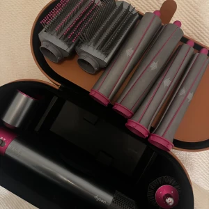 Dyson Airwrap med tillbehör och väska | EXTRA LÅNG LOCK BARREL - Säljer en Dyson Airwrap i svart och fuchsia med flera stylingtillbehör som borstar och locktillbehör med extra lång barrel för långt hår.