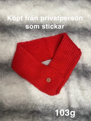 Röd stickad halsduk med knapp - Säljer en handstickad röd halsduk med grovstickad struktur och en dekorativ knapp framtill. Halsduk har en enkel, klassisk form. Färgen är intensivt röd och materialet känns varmt och mysigt.🌸 Köpt från en privatperson som gör egna. Fint använt skick.