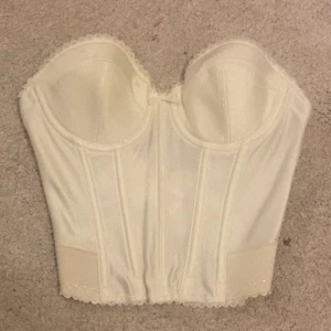 Vit korsett med spetskant - Säljer en så snygg vit korsett med formade kupor i silke