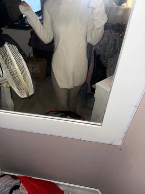 Beige ribbad polotröja med slits - Säljer en beige ribbad polotröja med lång ärm och slits på sidan. Tröjan är stickad och har en hög krage som ger en chill vibe. Passformen är loose och längden är lite längre, perfekt till mjukis eller jeans.