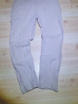 Beige chinos från 157, storlek M - Säljer ett par klassiska beige chinos från 157 i storlek M. Byxorna har rak passform, knappgylf och är tillverkade i mjuk bomull. Perfekta till en avslappnad stil och enkla att matcha med det mesta.