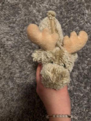 Beige pälspensskrin med dragkedja - Säljer en beige pälspenskriv i syntetmaterial, designad som en älg med mjuka horn och broderad text 'I ♥ Sweden' på insidan. 💕