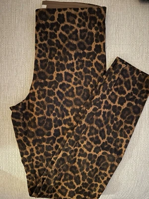 H&M Leopardmönstrade byxor i brun och svart - Snygga byxor med leopardmönster i bruna och svarta toner. De har en passform med stretch och är tillverkade i ett mjukt tyg som känns skönt mot huden. Inga fickor.