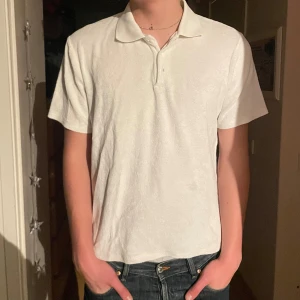 Vit piké från Jack & Jones - Säljer en klassisk vit pikétröja från Jack & Jones Premium. Tröjan har korta ärmar, krage och knappar vid halsen. Materialet känns mjukt och bekvämt, perfekt för en chill stil. Passar dig som gillar enkel och stilren design.