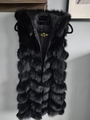 Garoff pälsväst - Säljer en svart pälsväst, den är i  längre modell och har stor luva. Storlek M, nypris 3899:- 