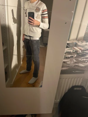 Tommy hilfiger Cardigan - Säljer en vit kofta från Hogwarts med coola patchar och broderade detaljer på bröstet. Koftan har ribbade muddar, knappar framtill och snygga ränder i svart, röd och beige på ena ärmen. Perfekt för dig som gillar unik stil. Det är för 8 år tror jag det är men passar till 140-157.  Jag på bild är 157 cm och huset sitter lite tajt som de flesta personerna gillar. Har små fläckar som går säkert bort. Fickorna har hål som är enkelt att sy ihop. Skriv privat för fler bilder. Från Tommy hilfiger.
