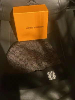 Rutig svart grå mössa - Rutig svart grå mössa helt ok skick lite solbränd på baksidan men man får en box med