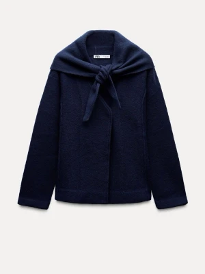 Mörkblå omlottjacka från Zara - Snygg mörkblå jacka från Zara med omlottkrage som kan knytas framtill. Jackan har lång ärm och är tillverkad i mjukt ullmaterial. Perfekt för dig som gillar stilrena och enkla plagg med en twist. Passar dig som vill ha något unikt i garderoben.