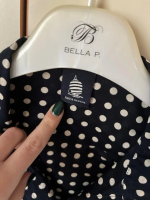 Marinblå prickig skjorta Marina Yachting - Snygg marinblå skjorta från Marina Yachting med vita prickar och klassisk krage. Skjortan har lång ärm och knappar framtill. Materialet känns lätt och luftigt, perfekt för dig som gillar stilrena mönster med lite edge.