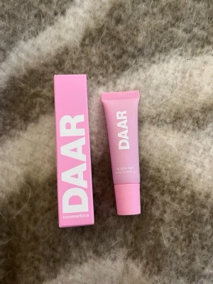 DAAR Lip Glow Balm Sweet Strawberry - Säljer en DAAR lip glow balm i färgen Sweet Strawberry. Tuben är ljusrosa med vit text och rymmer 10 ml. Ger glansiga och återfuktade läppar med en hint av jordgubb. Kommer i en snygg rosa förpackning. Perfekt att ha med i väskan för extra glow.