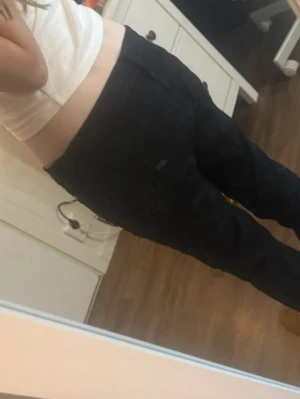 Svarta Miss Sixty jeans med kedja Str XS - Säljer ett par svarta jeans från Miss Sixty, modell Radio. Byxorna har låg midja och smal passform med snygga silverfärgade dragkedjor och en kedja framtill. Materialet är bomull med lite stretch för extra komfort. Snygga💕