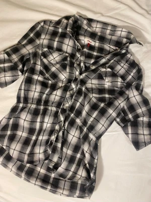 Superfin babydoll rutig piké - Så snygg svart och vit trekvarts tröja med fin brodyr och fickor. Detaljerna på denna tröja är så fina och modellen på tröjan är jättesnygg. 