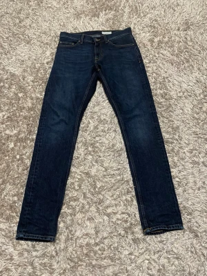 Mörkblå Tiger of Sweden jeans  - Snygga mörkblå Tiger of  Sweden slim fit jeans med strolek W30 L34. Jeansen har en stilren look med kontrastsömmar och är tillverkade i slitstarkt bomullsjeansmaterial. Perfekta för dig som gillar en tidlös och enkel stil.
