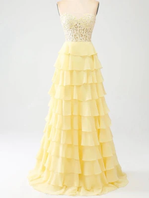 Ljusgul långklänning med spetsliv - Drömmig ljusgul balklänning med volangkjol i flera lager och axelbandslös design med fin spetsdetalj. Den kan justeras i ryggen så passar flera storlekar . Är 170